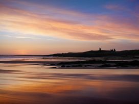 A view of the beach and distant castle ruins at 1 Sunny Brae Embleton