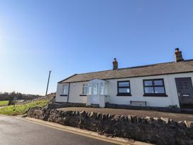 A house with a front door and windows at Harry's Cottage in Embleton