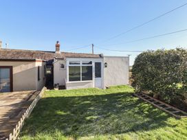 An outdoor view of a cottage with a door and window at Harry's Cottage in Embleton