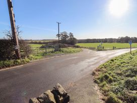 A road intersection with a gate and sign at Harry's Cottage in Embleton