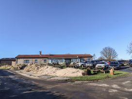 A building with cars parked outside at Harry's Cottage in Embleton