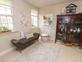 A snug with a sofa and cabinet at The Music Box in Beaumaris