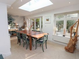 A dining room with a large table and chairs at The Music Box in Beaumaris