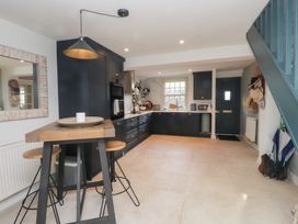 A kitchen with dark cabinets and a wooden counter at The Music Box in Beaumaris