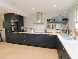 A kitchen with cabinets and a sink at The Music Box in Beaumaris