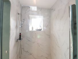 A shower with a window and soap dispenser at The Music Box Beaumaris