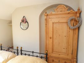 A bedroom with a bed and wardrobe at The Music Box in Beaumaris