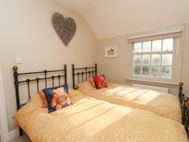 A bedroom with two beds and a large window at The Music Box in Beaumaris