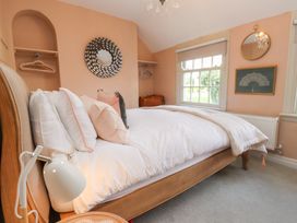 A bedroom with a bed and a window at The Music Box in Beaumaris