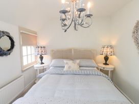 A bedroom with a bed, bedside tables and lamps at The Music Box in Beaumaris