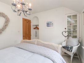 A bedroom with a bed and a wardrobe at The Music Box in Beaumaris