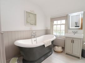 A bathroom with a bathtub and sink at The Music Box in Beaumaris