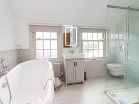 A bathroom with a bathtub, sink, and shower at The Music Box in Beaumaris