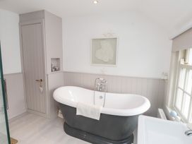 A bathroom with a freestanding bathtub and a sink at The Music Box in Beaumaris