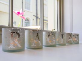 Candles arranged on table with a flower visible through the window at Tri Raglan Bach Beaumaris