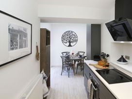 A kitchen with a dining table and chairs at Tri Raglan Bach Beaumaris