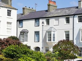 A view of houses with windows and a garden at Tri Raglan Bach in Beaumaris