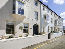 A row of houses with windows and a door at Tri Raglan Bach in Beaumaris