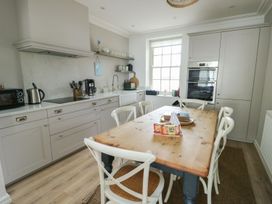 A kitchen with a table and chairs at Tri Raglan Mawr in Beaumaris