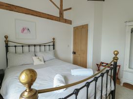 A bedroom with a bed and artwork on the wall at Tri Raglan Mawr Beaumaris