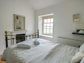 A bedroom with a bed and window at Tri Raglan Mawr in Beaumaris