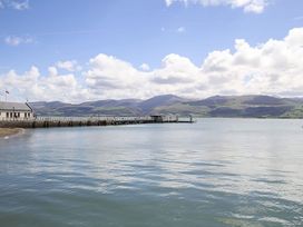 A view of a pier and mountains at Tri Raglan Mawr in Beaumaris