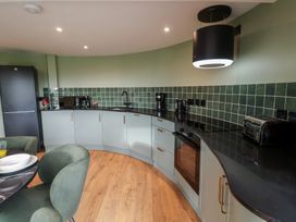 A kitchen with modern appliances and curved countertops at Unit 1 Ipswich