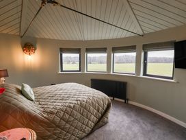 A bedroom with a bed and windows at Unit 1 in Ipswich