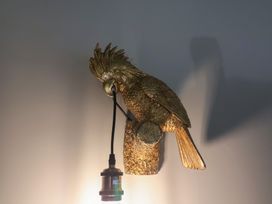 A bird sculpture lamp mounted on a wall at Unit 1 Ipswich