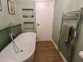 A bathroom with a bathtub and towel rail at Unit 1 in Ipswich