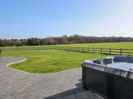 A garden featuring a hot tub and a paved patio at The Corn Silo in Ipswich
