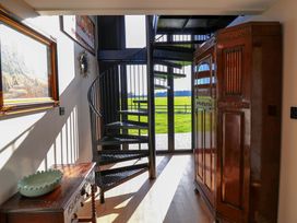 A hallway with a spiral staircase and wardrobe at The Corn Silo in Ipswich