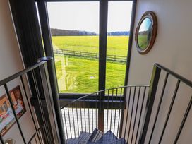 A staircase with a window and mirror at The Corn Silo in Ipswich