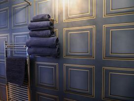 A bathroom with towels on a rack and patterned wall at Unit 2 Ipswich
