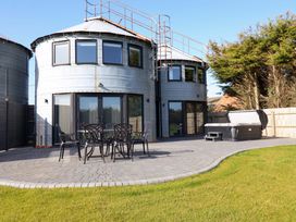 An outdoor area with a table and chairs near a hot tub at The Barley Silo in Ipswich