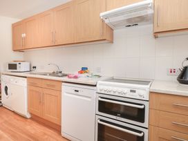 A kitchen with appliances and cabinetry at Ty'r Ddraig in Dartmouth