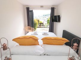 A bedroom with a bed and television at Ty'r Ddraig in Dartmouth