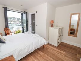 A bedroom with a bed and dresser at Ty'r Ddraig in Dartmouth