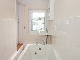 A bathroom with a bathtub and sink at Ty'r Ddraig in Dartmouth