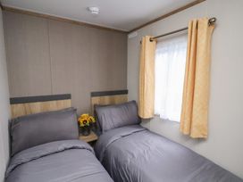 A bedroom with two beds and a vase of flowers at No. 7 Ivy in Scarborough