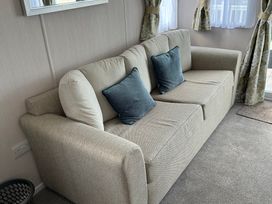 A living room with a sofa and cushions at TW89 in Exmouth