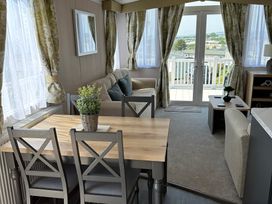 A living room with a dining area and sofa at TW89 in Exmouth