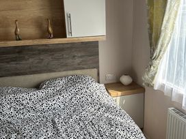 A bedroom with a bed and nightstand at TW89 in Exmouth
