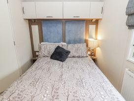 A bedroom with a bed and bedside lamp at Plot 42 in Carlisle