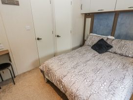 A bedroom with a bed and a chair at Plot 42 in Carlisle