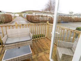 A deck area with chairs and a table at Plot 42 in Carlisle