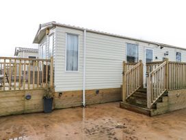A caravan with a wooden deck and stairs at Plot 42 in Carlisle