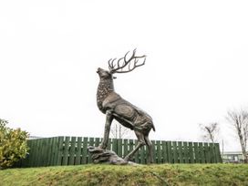 A deer statue next to a green fence at Plot 42 in Carlisle
