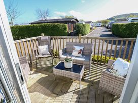 An outdoor seating area with wicker furniture and a table at Plot 42 Armathwaite