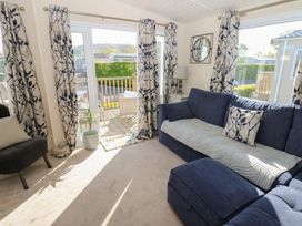 A living room with a blue sofa and sliding doors at Plot 42 in Armathwaite